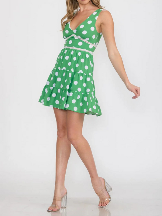 Woman wearing a green dress with white polka dots on a white background