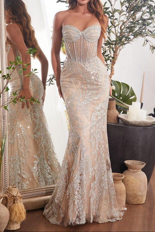 Woman in a strapless, beaded evening gown standing in a room with decorative elements.