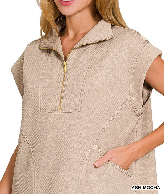 Woman wearing a beige sleeveless vest with a zipper on a white background
