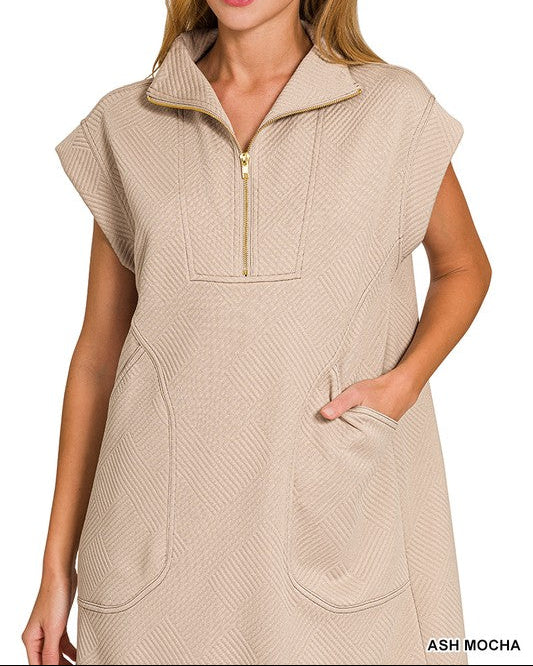 Woman wearing a beige sleeveless dress with a zipper on a white background