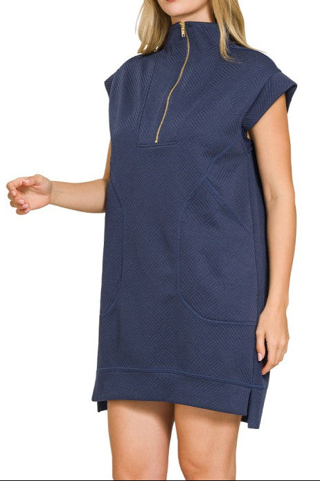 Woman wearing a navy blue dress with a zipper on a white background