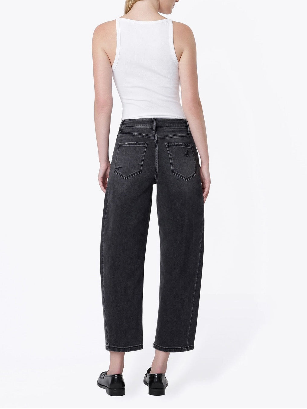 A woman shown from the back wearing a white ribbed tank top, dark gray wide-leg cropped jeans, and black shoes, photographed against a clean white studio background.
