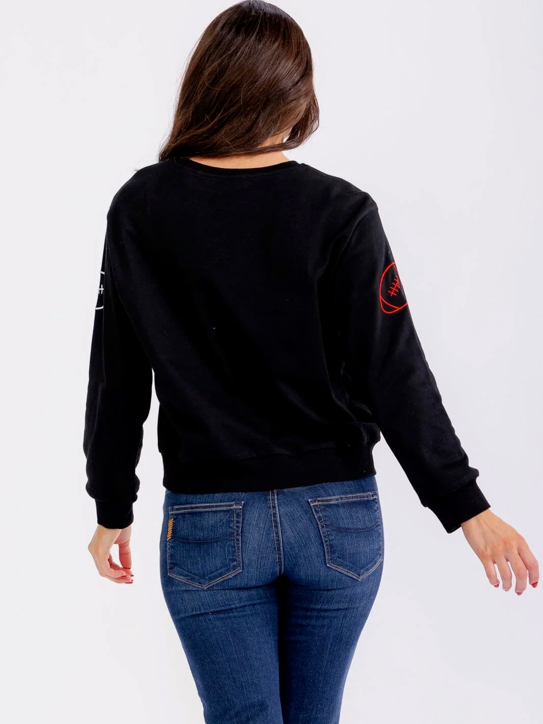 Person wearing a black sweatshirt with a red logo on a white background