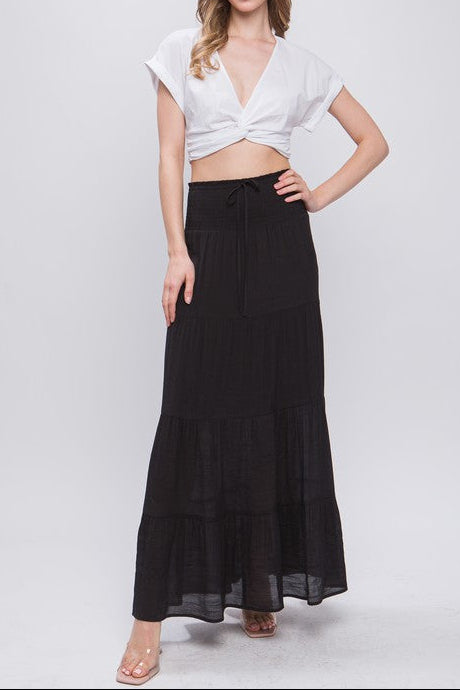 Woman wearing a white top and black skirt on a white background